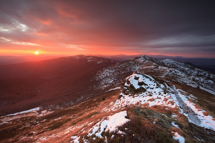 Sunset over snowy mountains and forest
