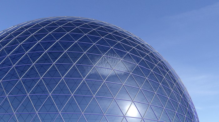 Glass geodesic dome against a blue sky
