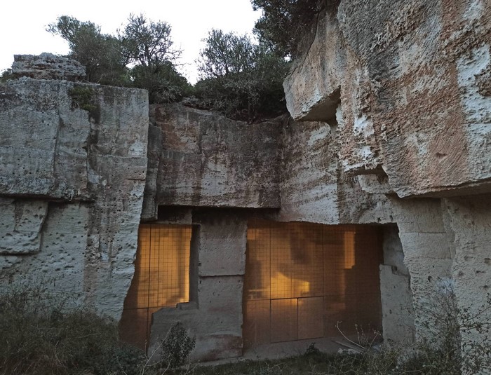 Stone quarry with a fenced opening and trees