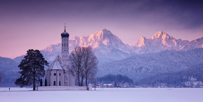 Winter church and mountains in Bavaria at sunset
