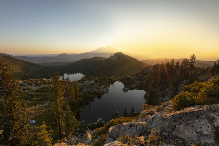 Sunset over mountain lakes with trees and rocks