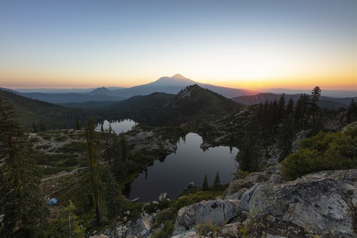 Sunset over mountain lakes with trees and rocks