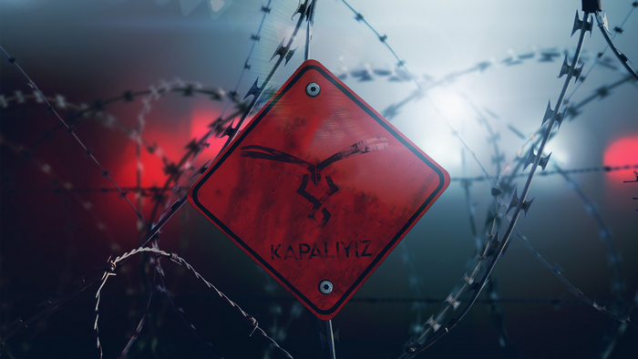 Red sign with Turkish text and barbed wire