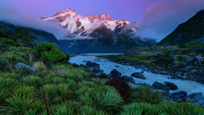 River flowing through a valley towards snow-capped mountains