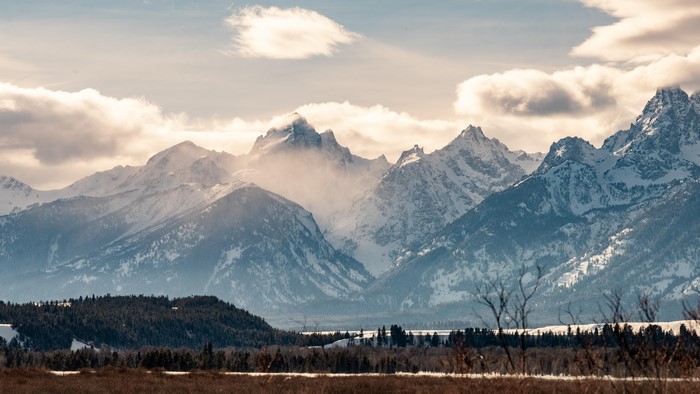 Snow-capped mountains under a cloudy sky
