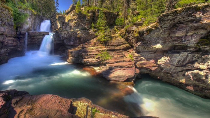 Waterfalls cascading over rocky cliffs in a forest