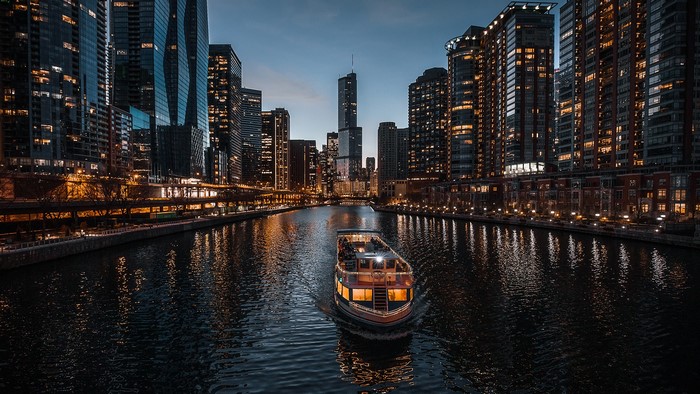Chicago River at night with boat and city lights
