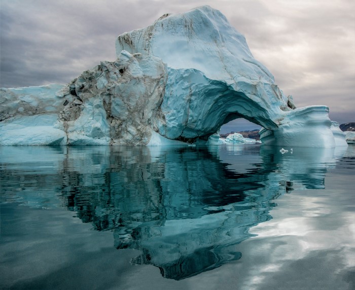 Iceberg with an arch in the Arctic ocean
