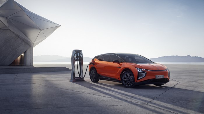 Orange HiPhi electric car charging at a futuristic station