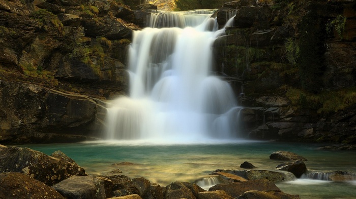 Waterfall cascading into a turquoise pool