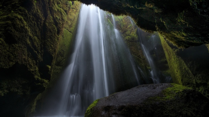 Moss-covered cave with a waterfall