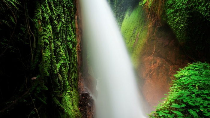 Waterfall cascading down moss-covered cliffs