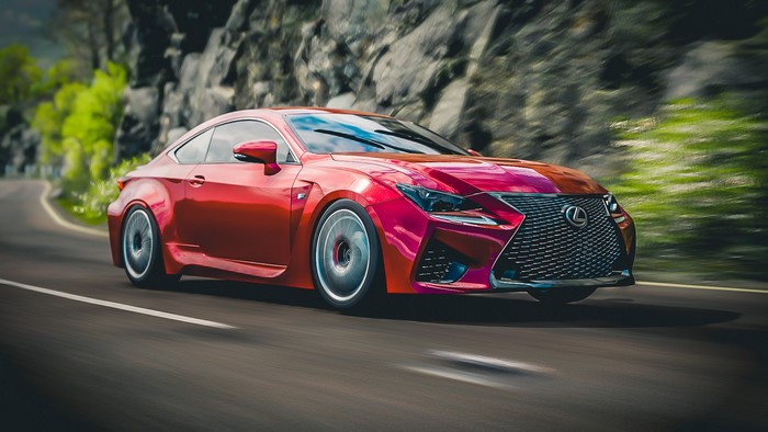 Red Lexus RC F Sport driving on a winding road