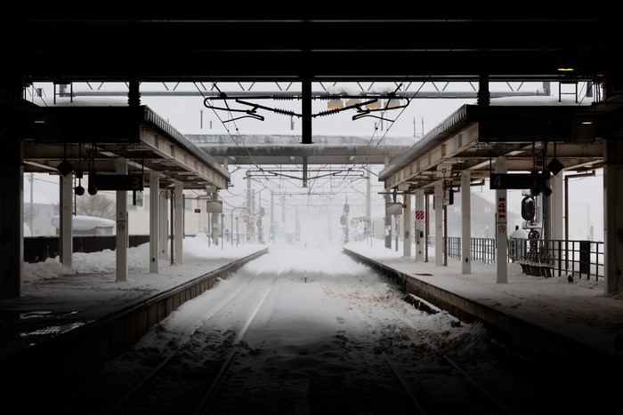 Snowy train station platforms with overhead wires