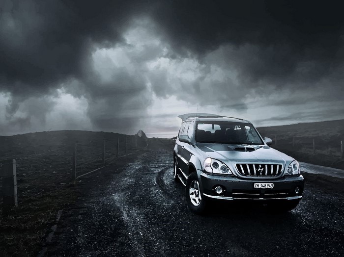 Hyundai SUV on a dirt road under stormy clouds