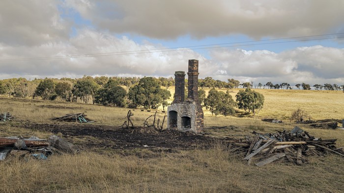 Ruined chimneys in a dry grassy field