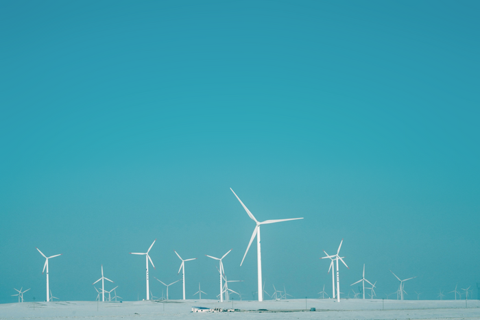 Wind turbines in a snowy landscape under a blue sky