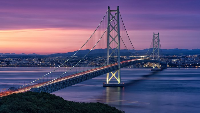 Akashi Kaikyo Bridge at sunset over city and water