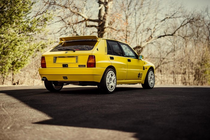 Yellow Lancia Delta Integrale parked on asphalt road