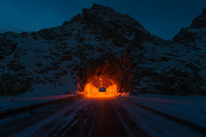 Snowy mountain tunnel entrance at night