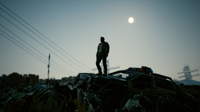 Man standing on a destroyed car in Cyberpunk 2077