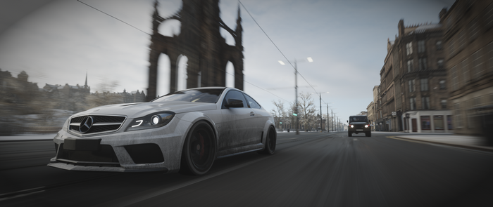 White Mercedes AMG driving on a city street