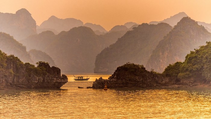 Boat sailing in Ha Long Bay, Vietnam during sunset