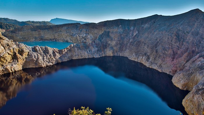 Volcanic crater lakes with rocky shores under a clear sky