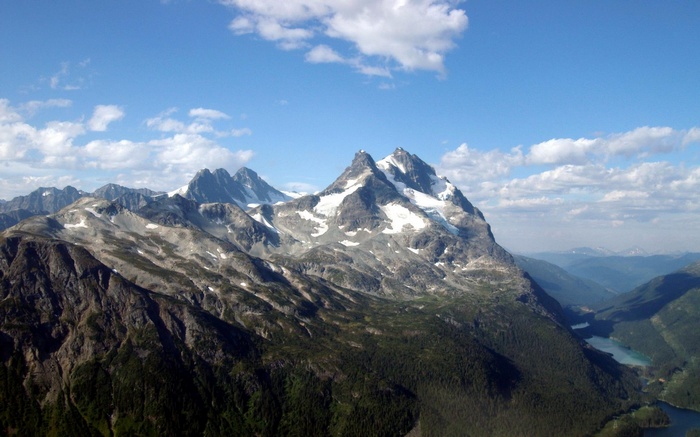 Snow-capped mountains and a blue lake under a cloudy sky
