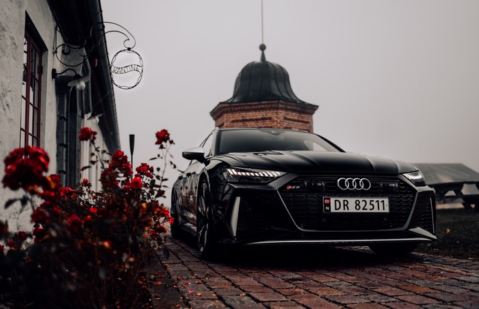 Audi RS6 parked near a building with red roses
