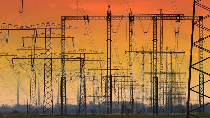 Power lines and wind turbines at sunset