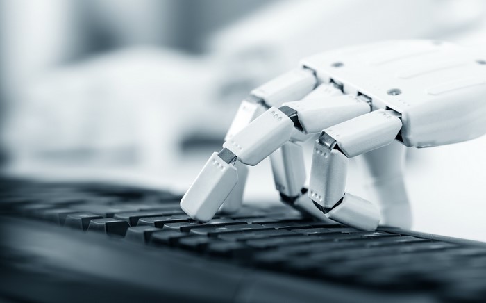 Robot hand typing on a keyboard