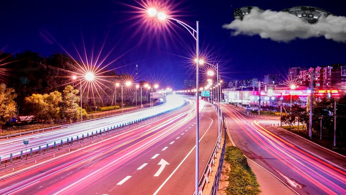 Night highway with light trails and UFOs