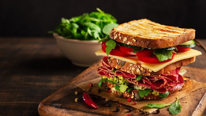 Stacked sandwich with meat, cheese, and vegetables