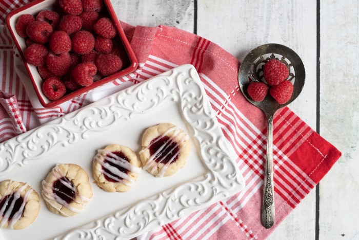 Raspberry thumbprint cookies with icing and fresh raspberries