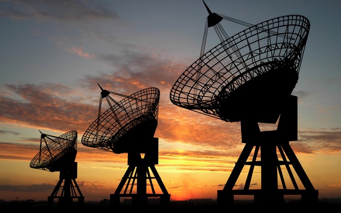 Radio telescopes silhouetted against a sunset sky