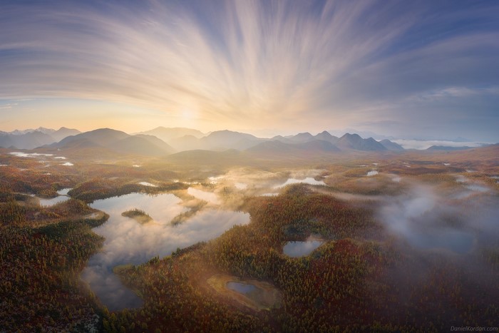 Aerial view of misty lakes and forests at sunrise