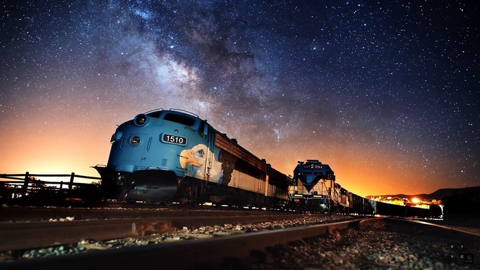 Blue diesel locomotives under the Milky Way