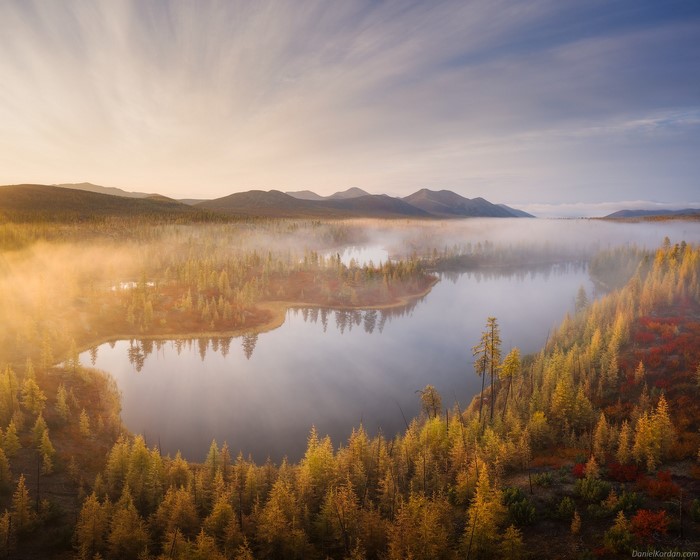 Misty lake and autumn forest at sunrise by Daniel Kordan