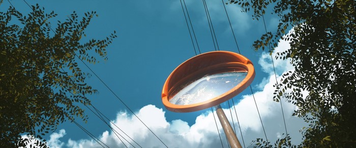 Convex mirror on a pole against blue sky and clouds