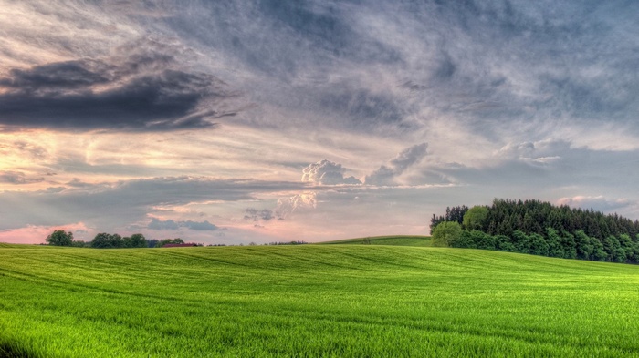 Green rolling hills under a cloudy sky