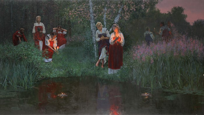 Women in traditional clothing with candles by a pond at dusk
