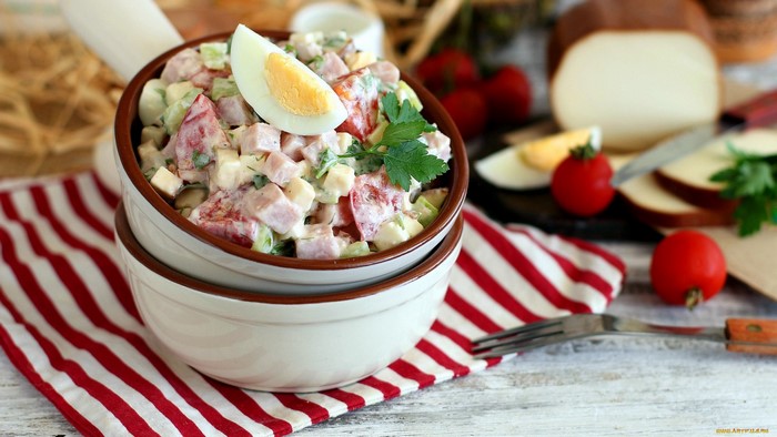 Salad with eggs, tomatoes, and ham in a bowl