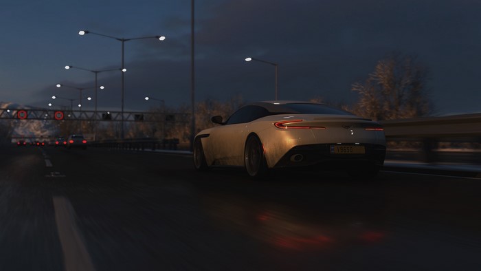 Aston Martin DB11 on a highway at dusk