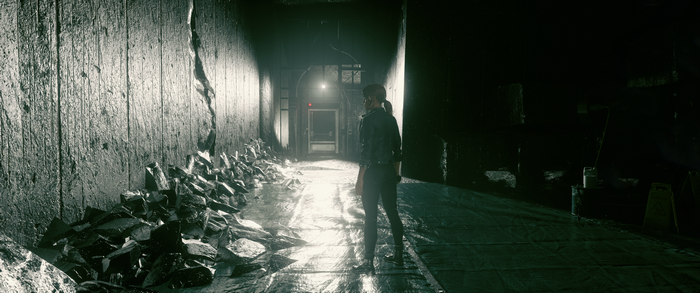 Jesse Faden from Control in a dark hallway