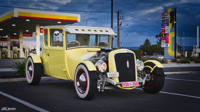 Yellow Hot Rod car at a gas station at night