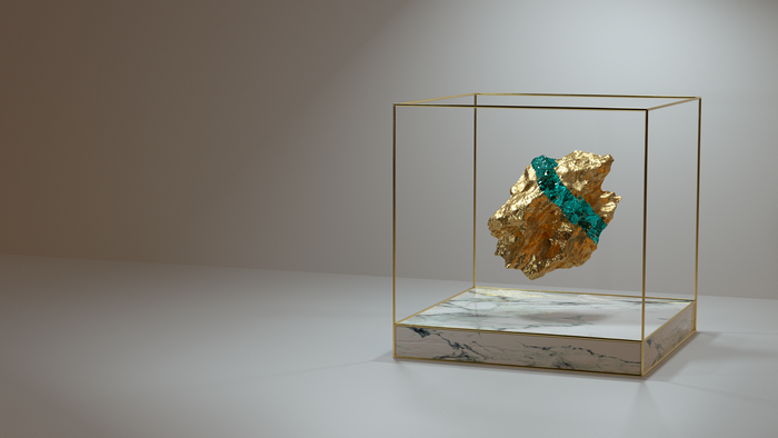 Gold nugget with emeralds in a display case