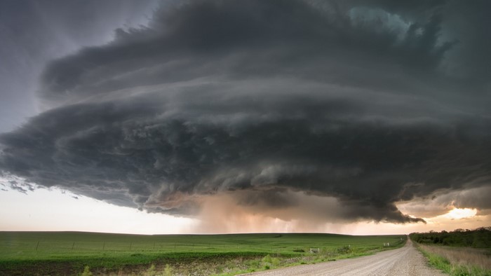 Storm clouds over a rural landscape with a dirt road