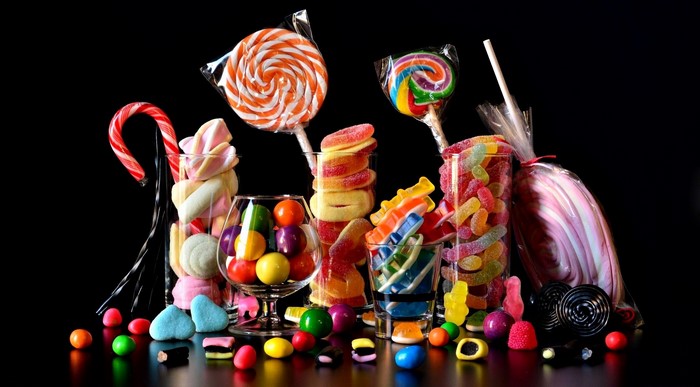 Assortment of colorful candies and lollipops on a black background