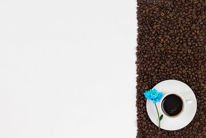 Coffee cup with blue flower and coffee beans